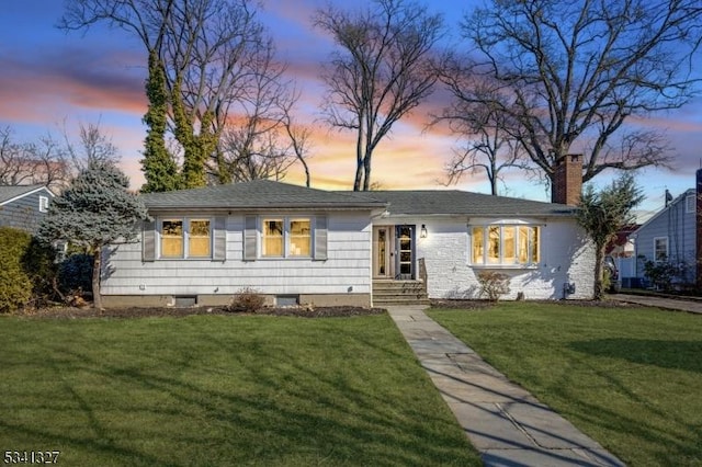 view of front of house featuring a chimney and a front yard