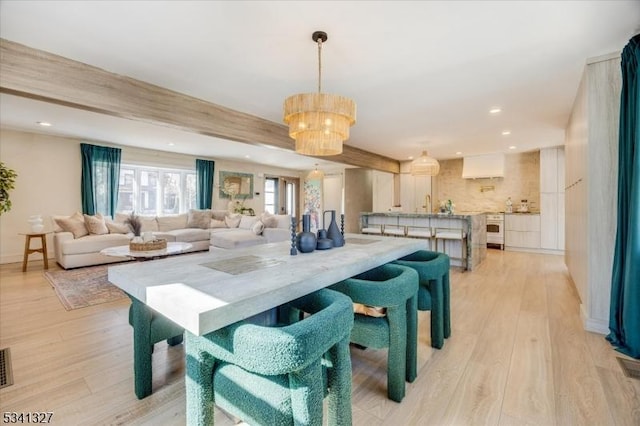 dining space with light wood-type flooring, baseboards, a notable chandelier, and recessed lighting