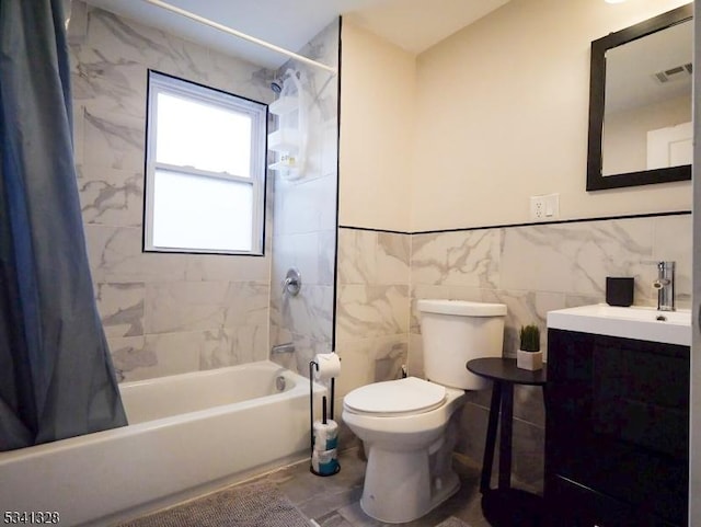 full bathroom featuring toilet, vanity, visible vents, tile walls, and shower / bath combo