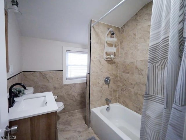 full bath with tile walls, toilet, shower / tub combo, vaulted ceiling, and vanity