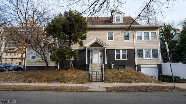 view of front of house featuring an attached garage and fence