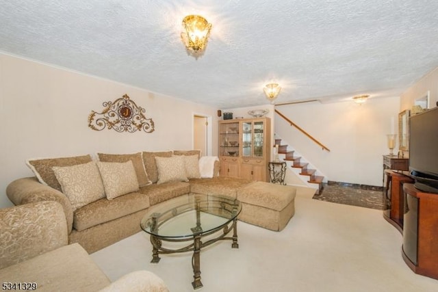 living area featuring carpet, stairs, and a textured ceiling