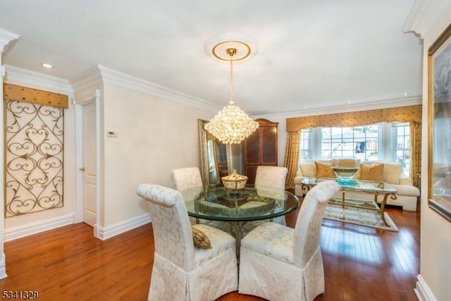 dining room featuring baseboards, ornamental molding, wood finished floors, and a notable chandelier