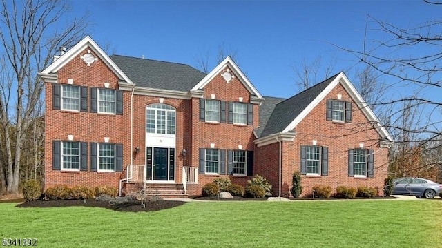 view of front facade featuring brick siding and a front yard