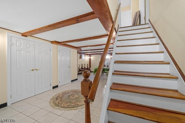 stairs with baseboards, beam ceiling, and tile patterned floors