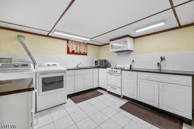 washroom with light tile patterned floors, laundry area, and washing machine and dryer