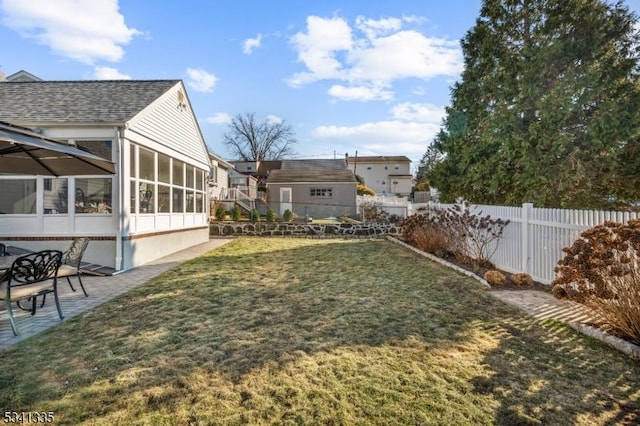 view of yard with a patio, fence, and a sunroom