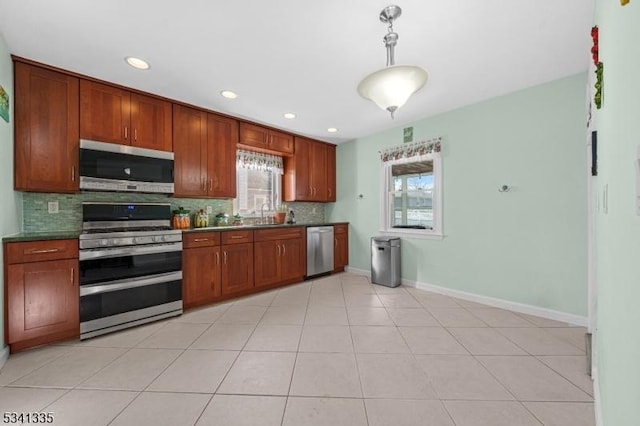 kitchen with stainless steel appliances, dark countertops, backsplash, and a healthy amount of sunlight