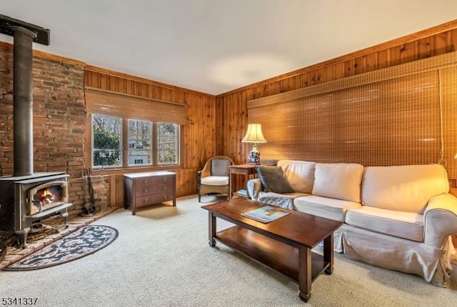 carpeted living area with a wood stove and wood walls