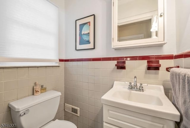 half bath featuring toilet, visible vents, and vanity