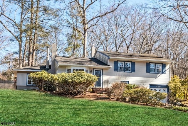 tri-level home featuring a front lawn and a chimney