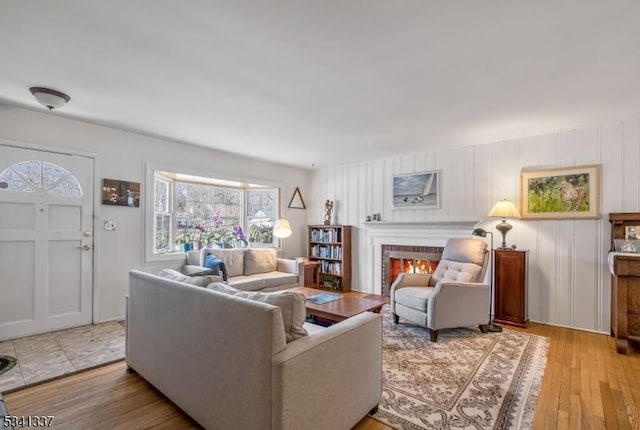 living room featuring light wood-type flooring and a brick fireplace