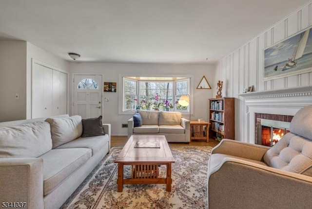 living area featuring a glass covered fireplace and wood finished floors