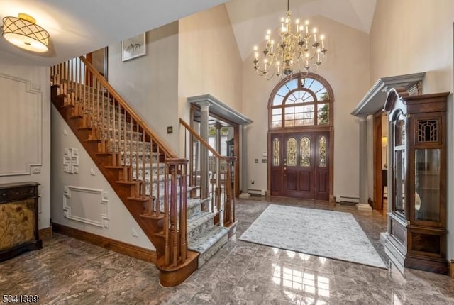 entrance foyer featuring decorative columns, baseboards, a baseboard radiator, stairway, and high vaulted ceiling