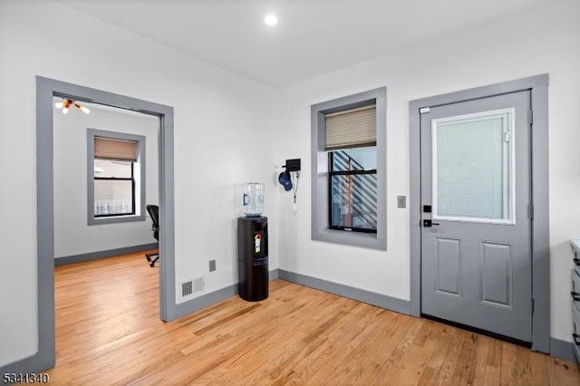 entrance foyer with light wood finished floors, baseboards, and visible vents