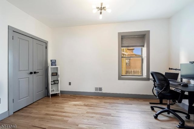 office space with light wood-style flooring, visible vents, a chandelier, and baseboards