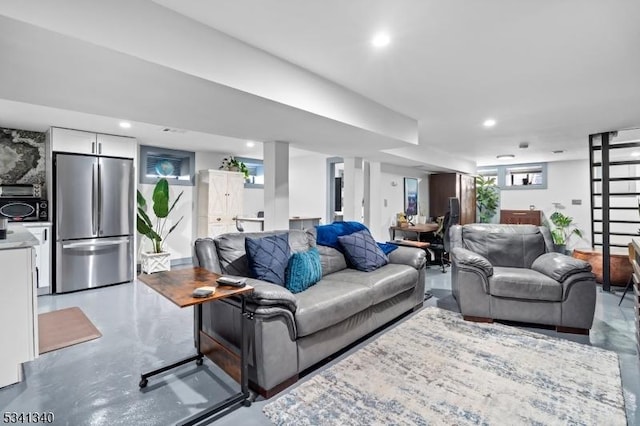 living area featuring finished concrete flooring and recessed lighting