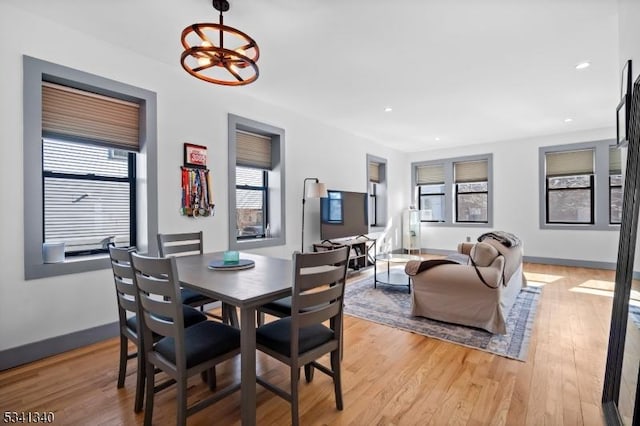 dining space with recessed lighting, a notable chandelier, light wood-style flooring, and baseboards