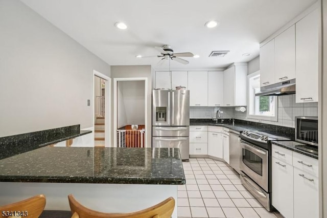 4 Dorrien Rd, Livingston Twp, NJ 07039 - kitchen with appliances with stainless steel finishes, backsplash, ceiling fan, under cabinet range hood, and white cabinetry