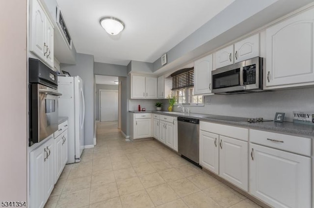 kitchen featuring stainless steel appliances, white cabinets, and a sink