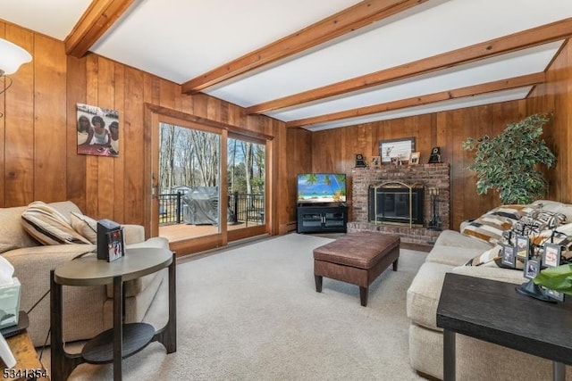 living room with carpet floors, beam ceiling, a fireplace, and wooden walls