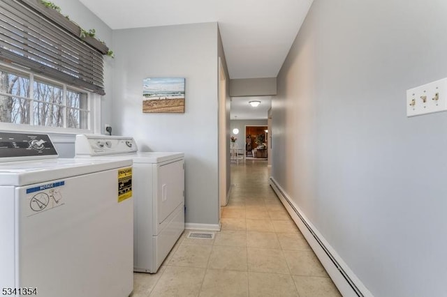 washroom featuring light tile patterned floors, a baseboard radiator, laundry area, baseboards, and independent washer and dryer