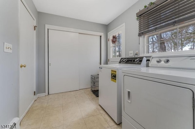 clothes washing area featuring laundry area, independent washer and dryer, and light tile patterned floors