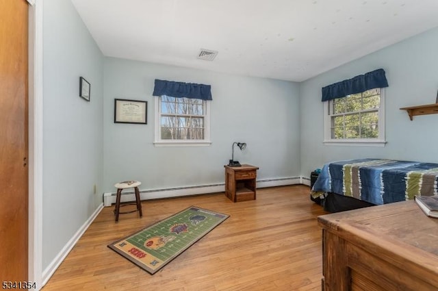 interior space featuring visible vents, a baseboard radiator, light wood-style flooring, and baseboards