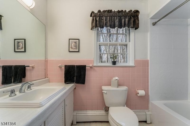 full bath featuring toilet, wainscoting, tile walls, and vanity