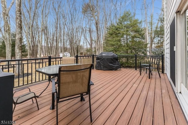 wooden deck with outdoor dining area and grilling area