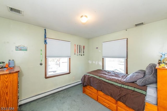 bedroom with a baseboard heating unit, carpet floors, multiple windows, and visible vents