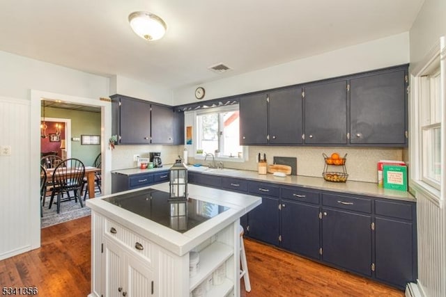 kitchen with visible vents, dark wood-style flooring, light countertops, open shelves, and backsplash