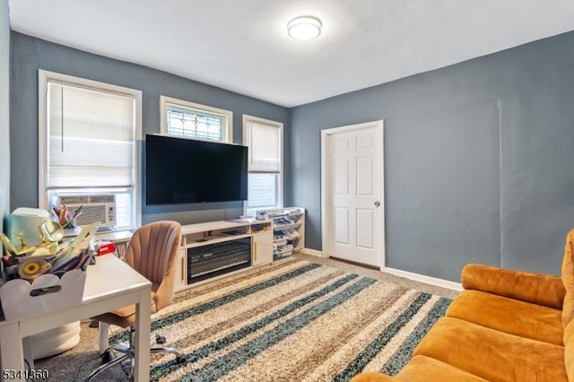 carpeted office space featuring cooling unit and baseboards