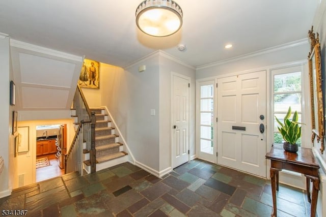 foyer with baseboards, stone tile floors, stairway, and crown molding