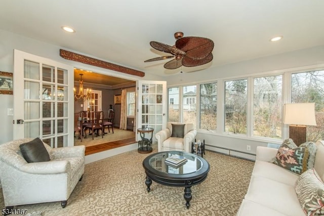 sunroom featuring a baseboard heating unit and ceiling fan with notable chandelier