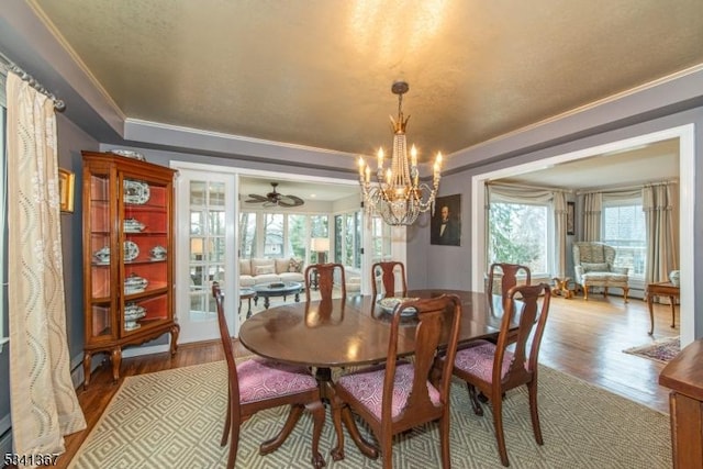 dining area featuring ornamental molding, wood finished floors, and a notable chandelier