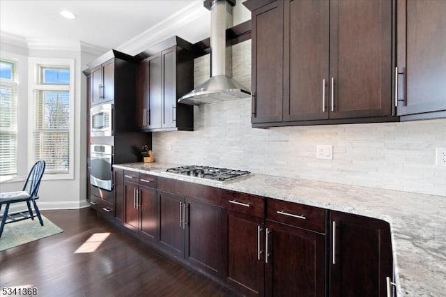 kitchen featuring stainless steel appliances, dark wood-type flooring, wall chimney exhaust hood, tasteful backsplash, and crown molding