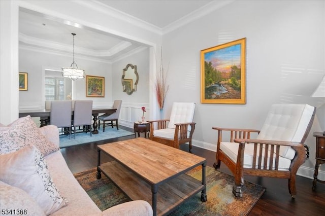 living area featuring a tray ceiling, ornamental molding, wood finished floors, and a notable chandelier