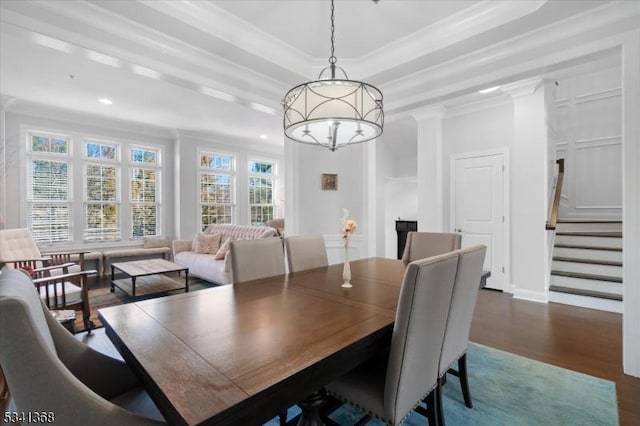 dining area featuring dark wood-type flooring, stairs, a tray ceiling, crown molding, and a chandelier