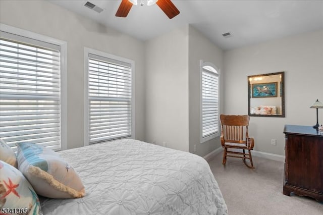 carpeted bedroom featuring visible vents, baseboards, and multiple windows