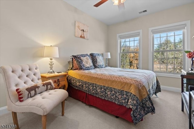 carpeted bedroom featuring a ceiling fan, visible vents, and baseboards