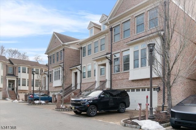 view of front of property with an attached garage and brick siding