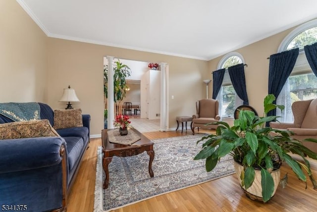 living room with ornamental molding, baseboards, and wood finished floors