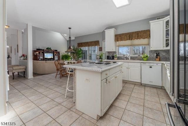 kitchen featuring light tile patterned floors, white cabinetry, light countertops, backsplash, and dishwasher