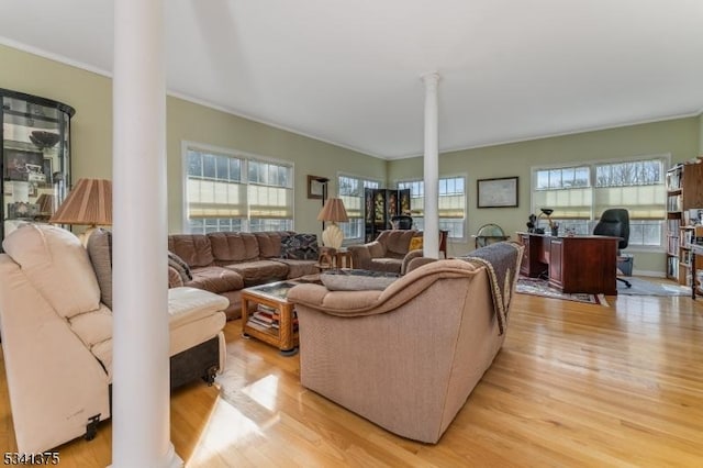 living room featuring ornamental molding, light wood-type flooring, and ornate columns