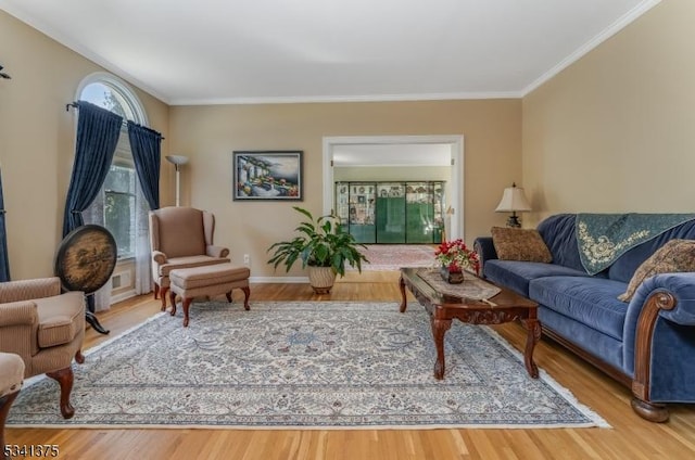 living room featuring ornamental molding, baseboards, and wood finished floors