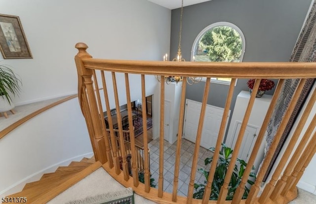 staircase with an inviting chandelier