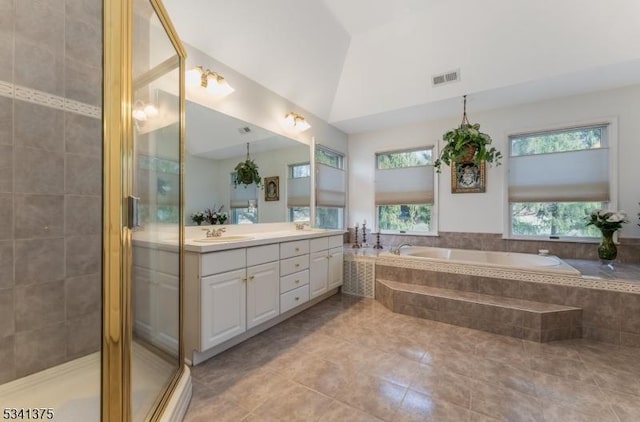 bathroom with visible vents, vaulted ceiling, a bath, double vanity, and a stall shower