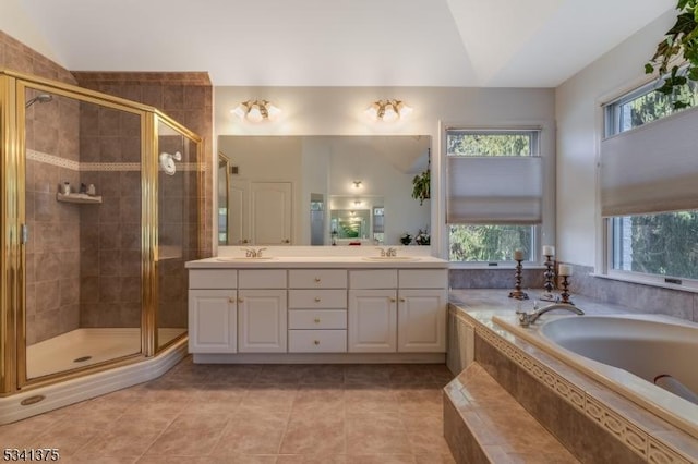 bathroom with a stall shower, a sink, a bath, and double vanity