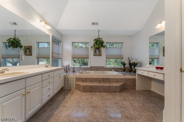 full bath featuring a garden tub, visible vents, vaulted ceiling, and a sink